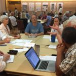 people at workshop gathered around a table