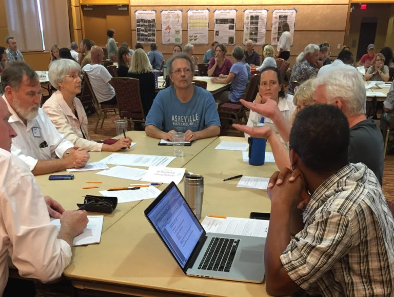 people at workshop gathered around a table