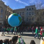 parade members carrying globe