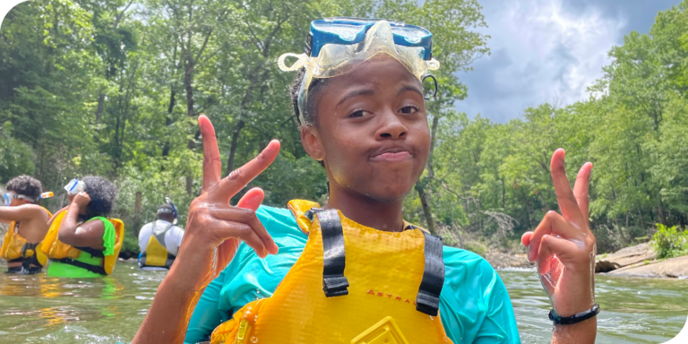kid standing in river with snorkeling gear