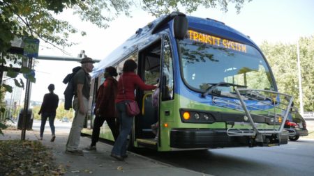 art transit bus taking on bus riders at a stop