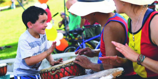 Child and adults drumming