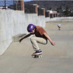 A young man skateboarding at the skate park