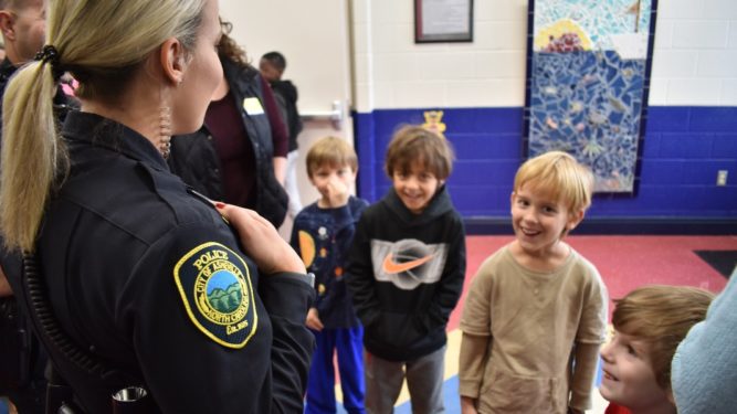 asheville police officer talking with young students