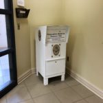 Photograph of the chest-high white prescription medicine drop-off bin in the lobby of the police department.