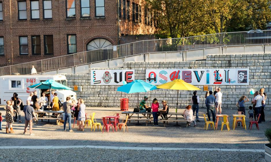 Image of people milling around food trucks at 68 Haywood