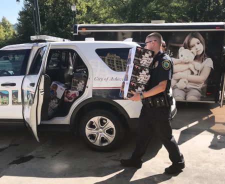 Police officer loading package into car