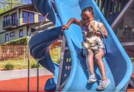 girl coming down slide at park