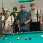 four men playing billiards