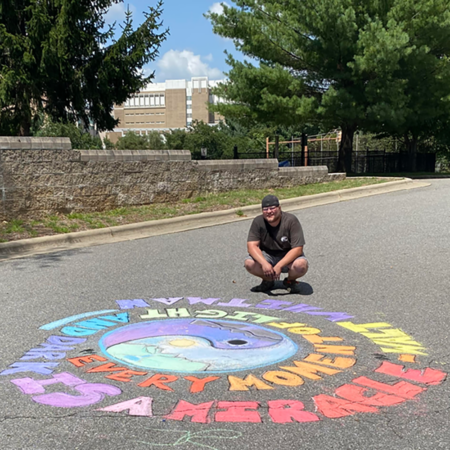 man with chalk art on asphalt