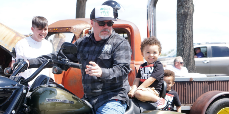 man on motorcycle with young child behind him