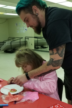 justyn travers with young girl decorating cookies