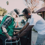 man helping older man with walker