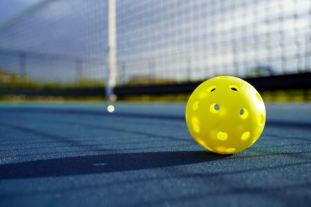 yellow pickleball on court