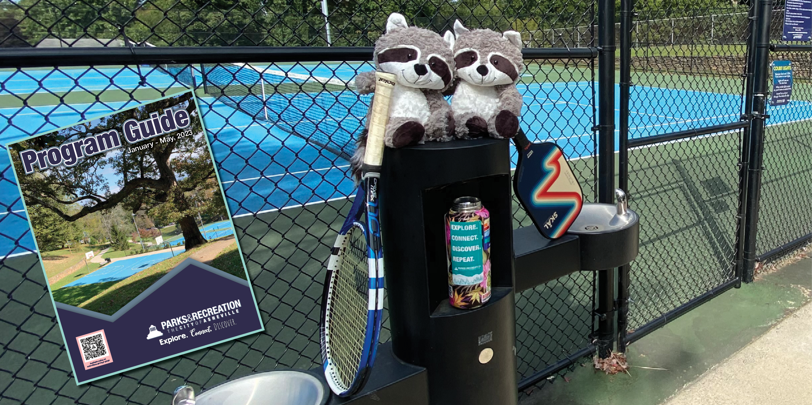 Stuffed animal raccoons with tennis racquet and pickleball paddle on water fountain with program guide cover inset