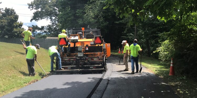 men working around an asphalt paving machine