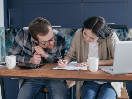 man and woman sitting at table going over paperwork