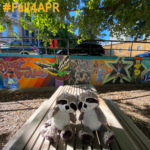 two stuffed raccoons sitting on table in front of graffiti art wall