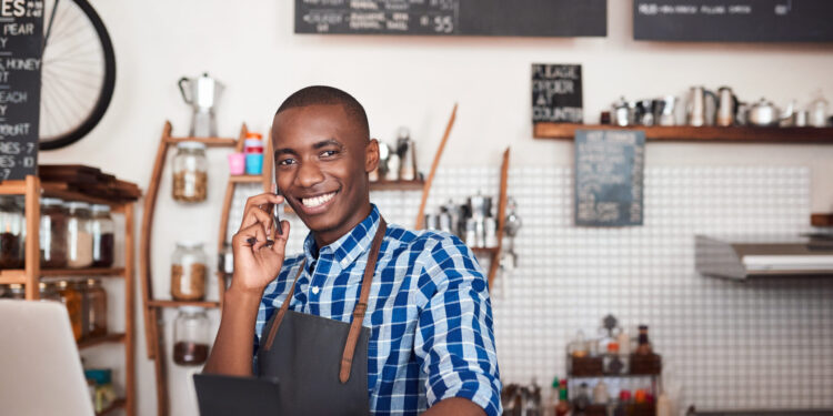 young black man at counter with laptop