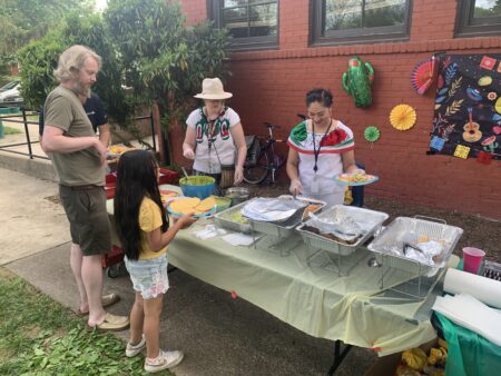 man and young girl at food table