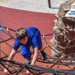 kid climbing on playground netting
