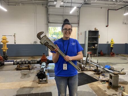 Brenna Cook holds massive wrench used in TAP training