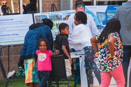 people gather around informational display board