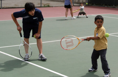 two young boys playing tennis