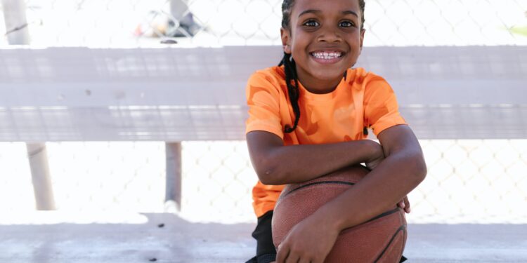 girl wearing orange shirt holding basketball