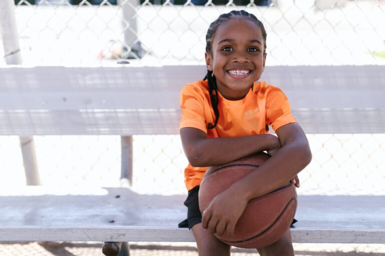 girl wearing orange shirt holding basketball