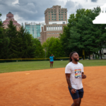 people playing kickball with city hall in the background