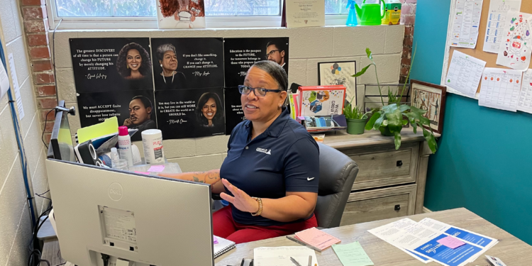 angel redmond sitting at desk wearing blue shirt