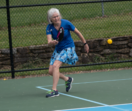 senior lady wearing blue playing pickleball