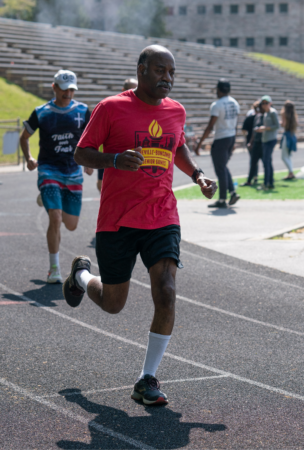 african american man wearing red shirt running on track