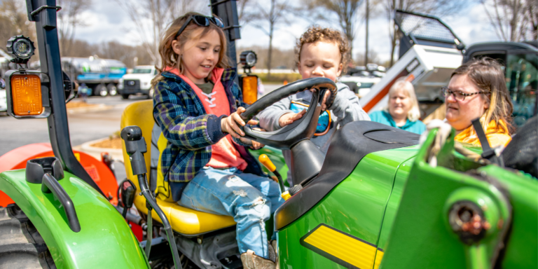 young girl on green tractor