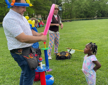 balloon artist with small girl