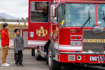 two boys looking into door of fire truck