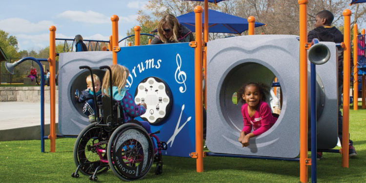 african american children and young girl in wheelchair playing on playground