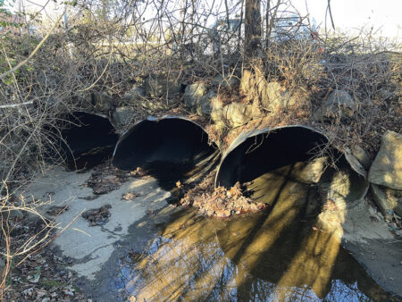 three culvert pipes with muddy water