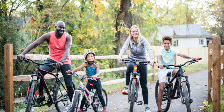 family of four riding bikes on the greenway