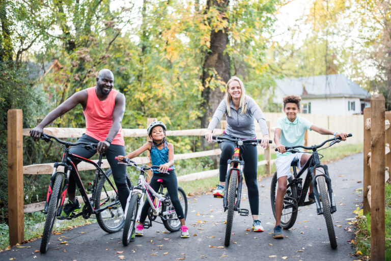 family of four riding bikes on the greenway