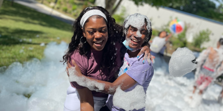 two young girls playing in foam bubbles