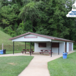picnic shelter with tables and a sidewalk at roger farmer park