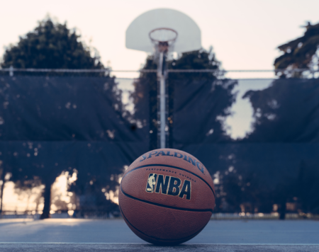 basketball court with hoop and ball in foreground