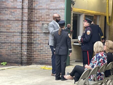 Staff member Marcus Kirkman prepares to deliver the National Anthem