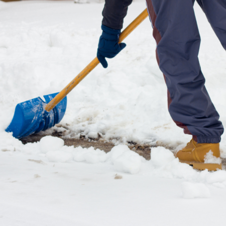 person shoveling snow with blue shovel