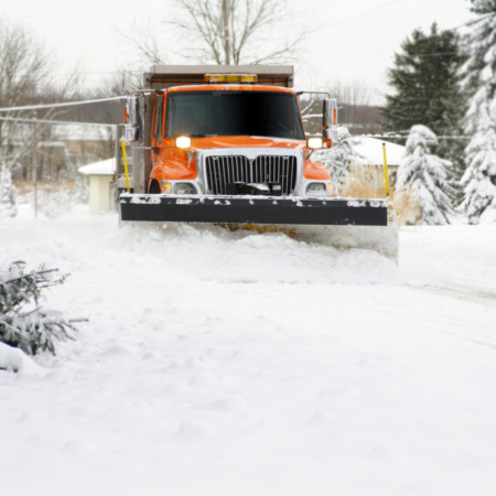 orange truck with snow plow on front