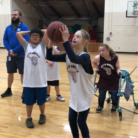 girl shooting basketball with white jersey on.