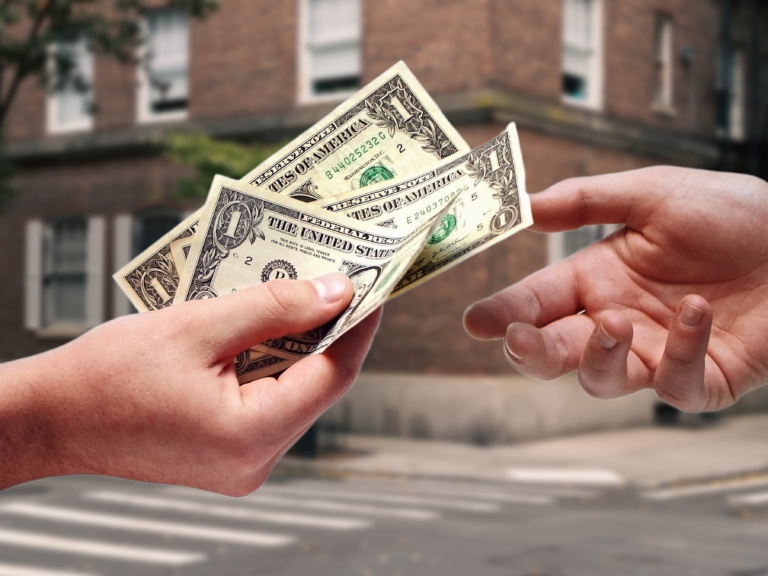 hands exchanging dollar bills