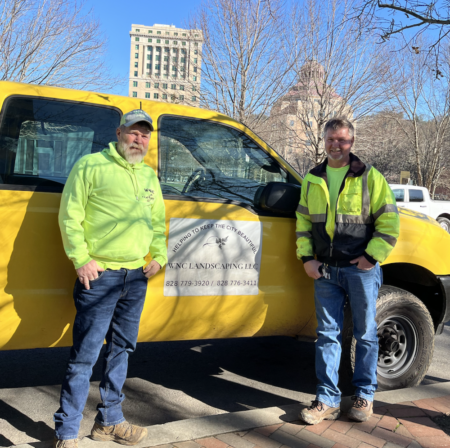 contracted cleaning service employees standing by yellow company truck